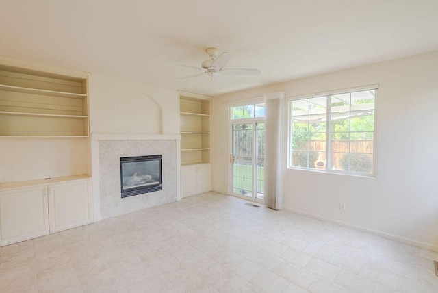 2413 San Remo Dr, Sparks, NV 89434 - unfurnished living room with built in shelves, a ceiling fan, a premium fireplace, and baseboards