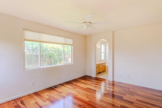 2413 San Remo Dr, Sparks, NV 89434 - unfurnished room with arched walkways, light wood-type flooring, a ceiling fan, and baseboards