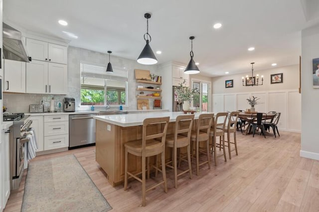 5470 Weatherby Ct, Reno, NV 89523 - kitchen featuring appliances with stainless steel finishes, a kitchen island, light countertops, white cabinets, and a chandelier