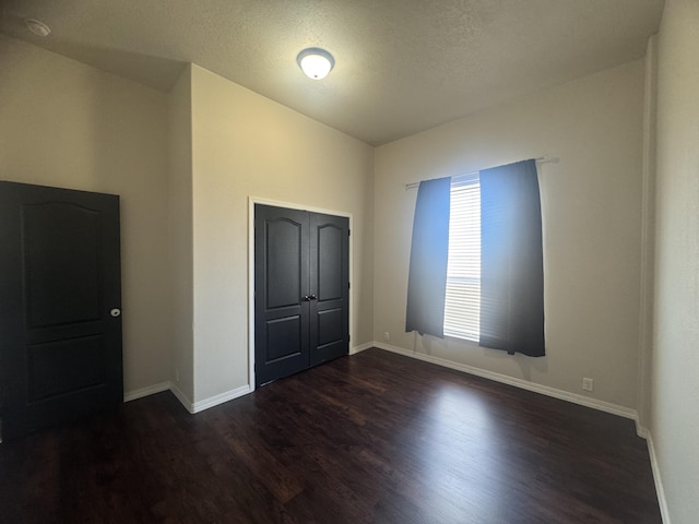 9485 Zaring Ave, Winnemucca, NV 89445 - unfurnished bedroom with dark wood-style flooring, a textured ceiling, and a closet