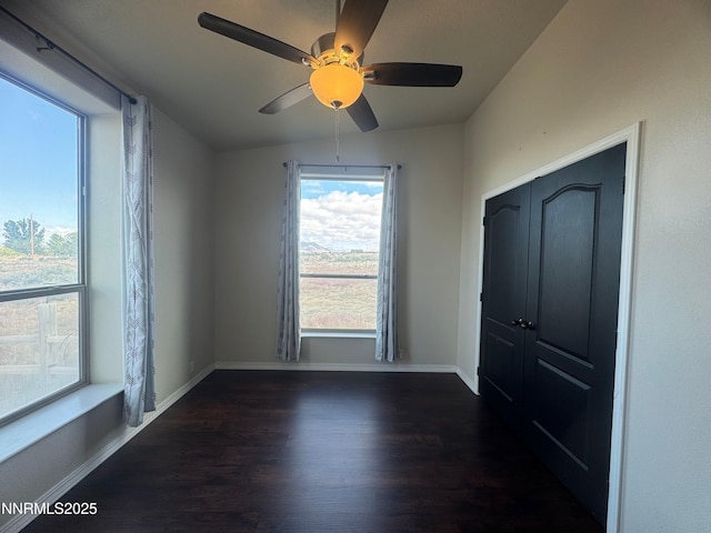 9485 Zaring Ave, Winnemucca, NV 89445 - unfurnished bedroom with wood finished floors, multiple windows, and ceiling fan