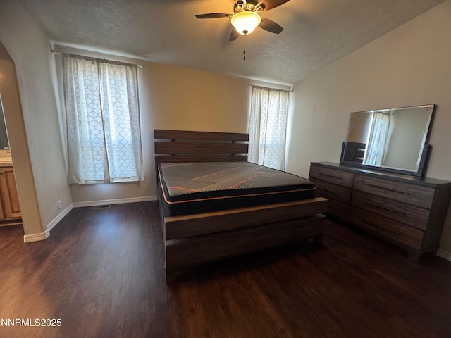 9485 Zaring Ave, Winnemucca, NV 89445 - bedroom featuring dark wood-style floors, arched walkways, a textured ceiling, a ceiling fan, and vaulted ceiling