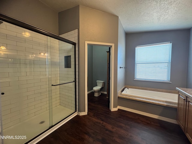 9485 Zaring Ave, Winnemucca, NV 89445 - full bath with wood finished floors, a shower stall, a bath, a textured ceiling, and vanity