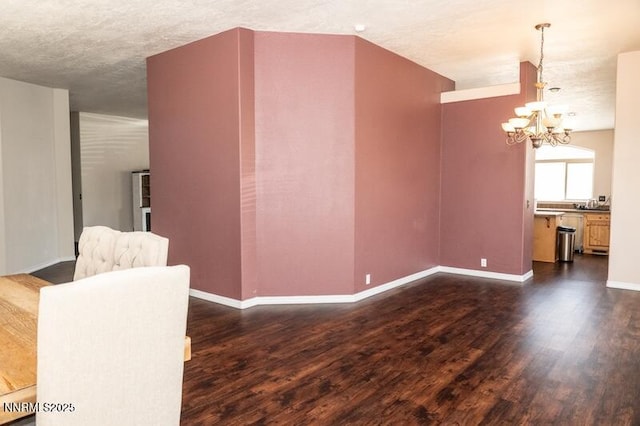 9485 Zaring Ave, Winnemucca, NV 89445 - unfurnished room featuring a chandelier, dark wood-style flooring, and a textured ceiling
