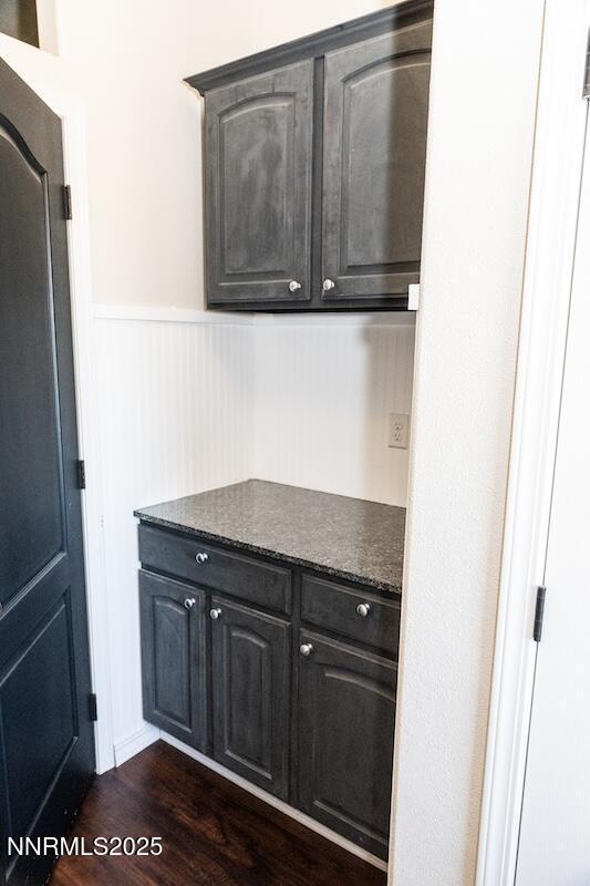 9485 Zaring Ave, Winnemucca, NV 89445 - kitchen with dark countertops, wainscoting, and dark wood-style flooring