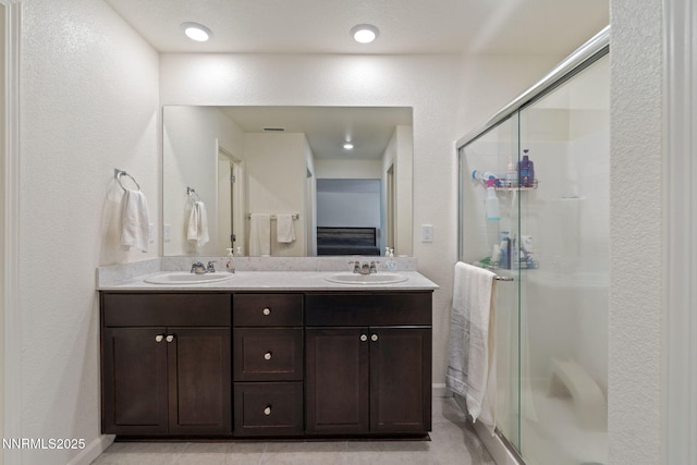 8944 Elk Ravine Dr, Reno, NV 89506 - bathroom with a stall shower, double vanity, baseboards, and a textured wall