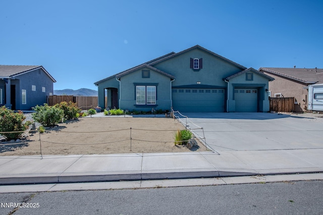 1501 Riverpark Pkwy, Dayton, NV 89403 - ranch-style home with a garage, concrete driveway, stucco siding, and a mountain view