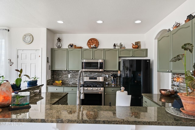 1501 Riverpark Pkwy, Dayton, NV 89403 - kitchen featuring green cabinetry, stainless steel appliances, tasteful backsplash, dark stone counters, and recessed lighting