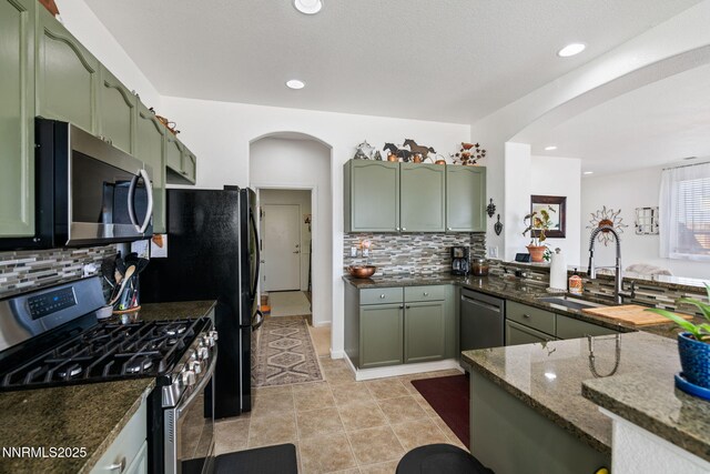 1501 Riverpark Pkwy, Dayton, NV 89403 - kitchen featuring appliances with stainless steel finishes, green cabinets, a sink, arched walkways, and recessed lighting
