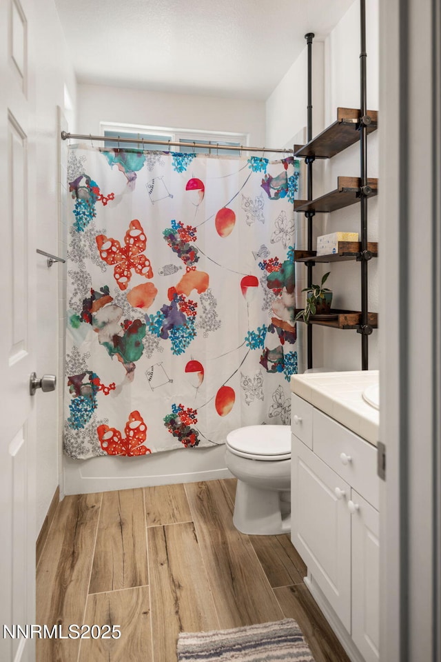 1501 Riverpark Pkwy, Dayton, NV 89403 - bathroom featuring wood finished floors, toilet, vanity, and shower / bathtub combination with curtain