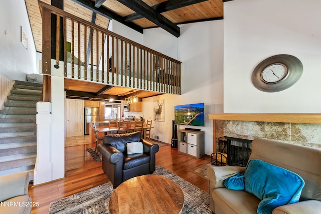 275 Tramway Dr Unit C, Stateline, NV 89449 - living area with stairs, wood finished floors, a tile fireplace, wooden ceiling with exposed beams, and a high ceiling