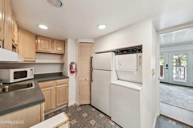 275 Tramway Dr Unit C, Stateline, NV 89449 - kitchen featuring stacked washer / dryer, light brown cabinetry, white appliances, dark countertops, and a sink