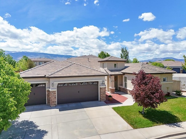 10555 Hampton Creek Dr, Reno, NV 89521 - prairie-style home with an attached garage, concrete driveway, stone siding, and a mountain view