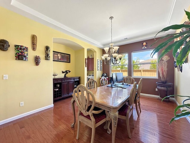 10555 Hampton Creek Dr, Reno, NV 89521 - dining area with a chandelier, arched walkways, baseboards, and dark wood finished floors