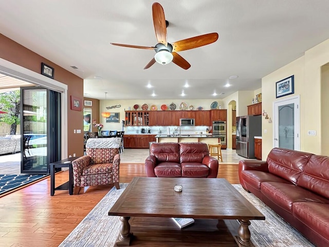 10555 Hampton Creek Dr, Reno, NV 89521 - living room featuring a ceiling fan, light wood-style flooring, arched walkways, and recessed lighting