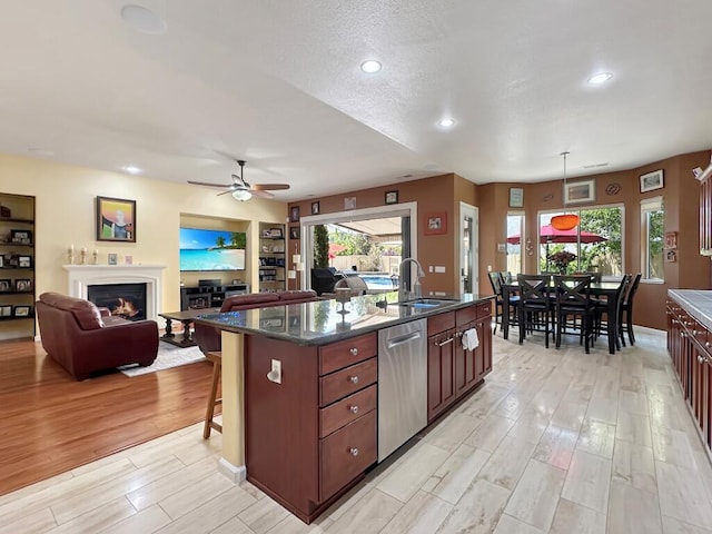 10555 Hampton Creek Dr, Reno, NV 89521 - kitchen featuring dishwasher, a sink, light wood finished floors, ceiling fan, and a kitchen breakfast bar
