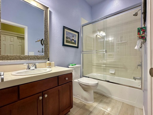 10555 Hampton Creek Dr, Reno, NV 89521 - bathroom with a textured wall, toilet, bath / shower combo with glass door, and vanity