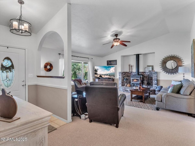 1992 Hackamore Ln, Gardnerville, NV 89410 - living area featuring vaulted ceiling, arched walkways, a wood stove, light colored carpet, and a ceiling fan