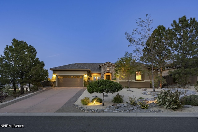 2698 Wind Feather Trl, Reno, NV 89511 - view of front of house featuring an attached garage, concrete driveway, stucco siding, and stone siding