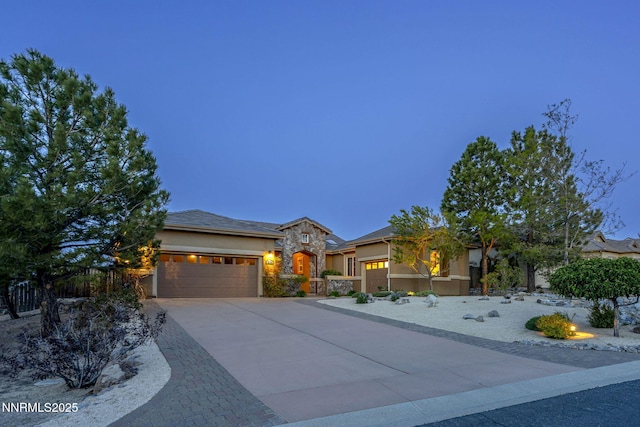 2698 Wind Feather Trl, Reno, NV 89511 - view of front of property with an attached garage, concrete driveway, stone siding, and stucco siding