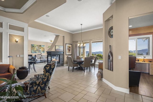 2698 Wind Feather Trl, Reno, NV 89511 - dining room with a chandelier, baseboards, a multi sided fireplace, and crown molding