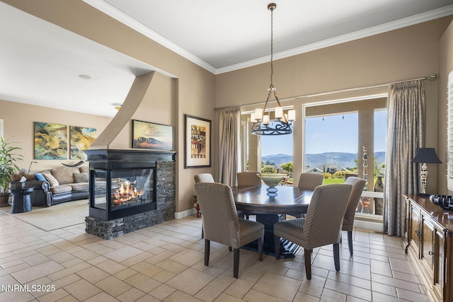 2698 Wind Feather Trl, Reno, NV 89511 - dining room with crown molding, a chandelier, a stone fireplace, a mountain view, and baseboards