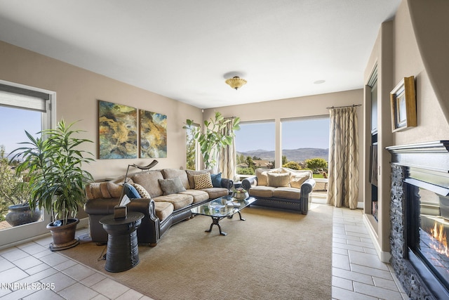 2698 Wind Feather Trl, Reno, NV 89511 - living room featuring a glass covered fireplace, light tile patterned flooring, and a mountain view