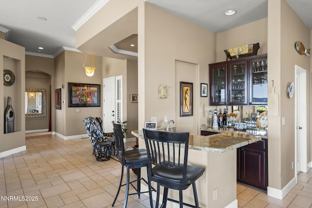 2698 Wind Feather Trl, Reno, NV 89511 - indoor wet bar featuring arched walkways, baseboards, recessed lighting, crown molding, and light tile patterned flooring