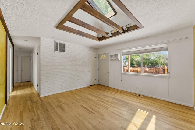 2480 Courtland Way, Sparks, NV 89431 - spare room featuring a textured ceiling, an AC wall unit, brick wall, wood finished floors, and baseboards