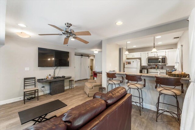 2249 Kietzke Ln Apt C, Reno, NV 89502 - living room featuring a barn door, a ceiling fan, wood finished floors, recessed lighting, and baseboards