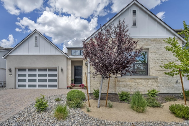 107 Bridlemoor Ct, Reno, NV 89511 - view of front of home featuring board and batten siding, stone siding, decorative driveway, a garage, and stucco siding