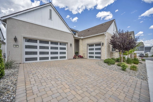 107 Bridlemoor Ct, Reno, NV 89511 - view of front of home with board and batten siding, an attached garage, decorative driveway, stucco siding, and stone siding