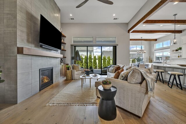 107 Bridlemoor Ct, Reno, NV 89511 - living area featuring ceiling fan, beamed ceiling, a tile fireplace, light wood finished floors, and recessed lighting