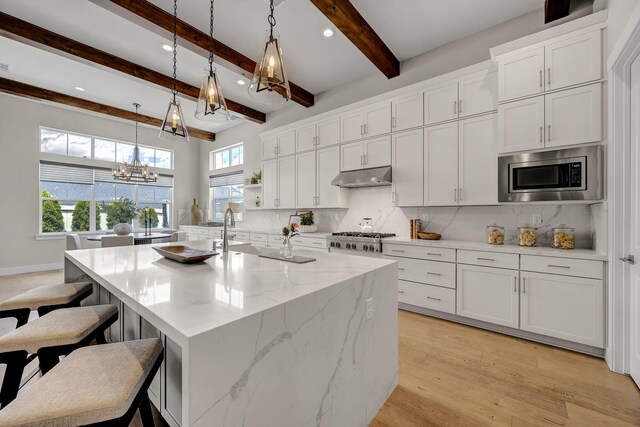 107 Bridlemoor Ct, Reno, NV 89511 - kitchen featuring stainless steel appliances, a chandelier, under cabinet range hood, tasteful backsplash, and beamed ceiling