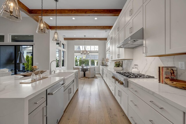 107 Bridlemoor Ct, Reno, NV 89511 - kitchen with dishwasher, under cabinet range hood, beamed ceiling, stainless steel gas cooktop, and light wood finished floors