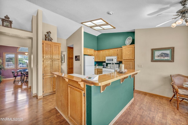 1408 N Santa Barbara Dr, Minden, NV 89423 - kitchen featuring white appliances, ceiling fan, vaulted ceiling, light wood-style flooring, and light countertops