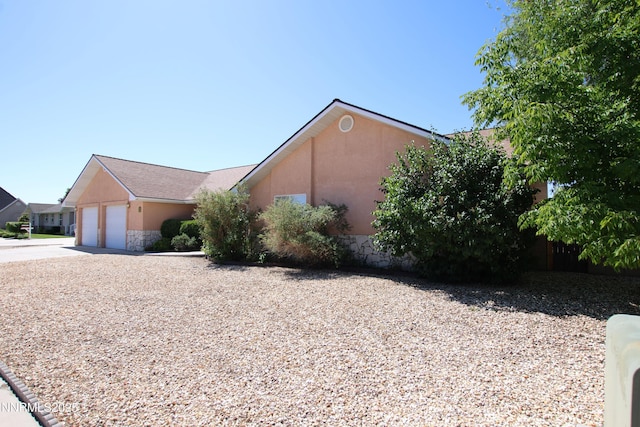 403 Ironwood Ct, Yerington, NV 89447 - view of side of property featuring driveway, stucco siding, and a garage