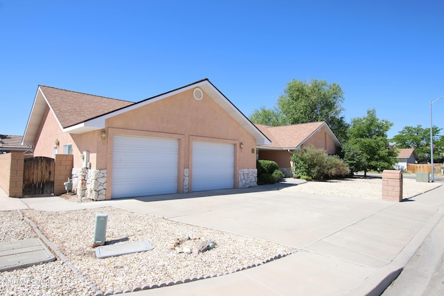 403 Ironwood Ct, Yerington, NV 89447 - ranch-style house with a garage, stone siding, stucco siding, and driveway