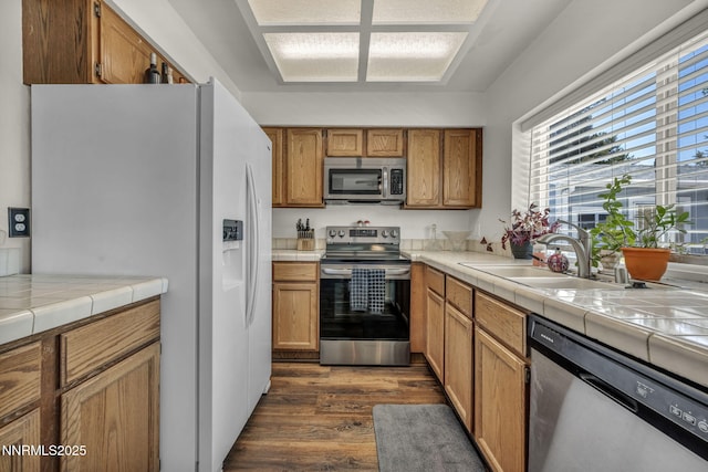 45 Stormy Ct, Sparks, NV 89436 - kitchen with stainless steel appliances, a sink, dark wood-style flooring, brown cabinetry, and tile counters