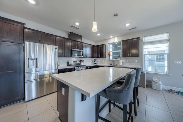 1855 Dark Horse Rd Unit B, Reno, NV 89521 - kitchen with appliances with stainless steel finishes, a sink, light tile patterned flooring, a center island, and dark brown cabinetry