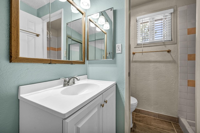 3760 Brant St, Reno, NV 89508 - full bath with toilet, vanity, a textured wall, a tile shower, and wood finished floors