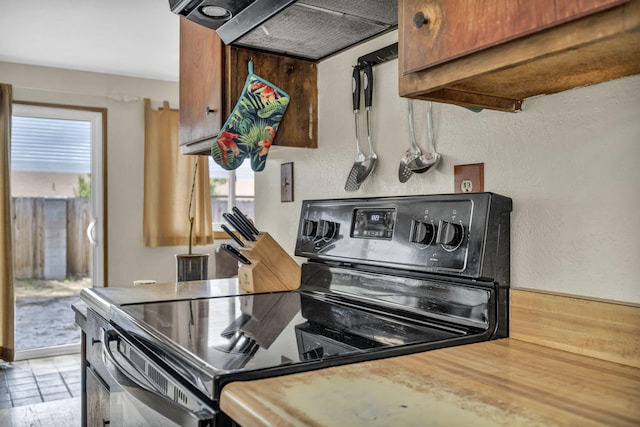 3760 Brant St, Reno, NV 89508 - kitchen with range with electric cooktop, exhaust hood, light countertops, and a textured wall