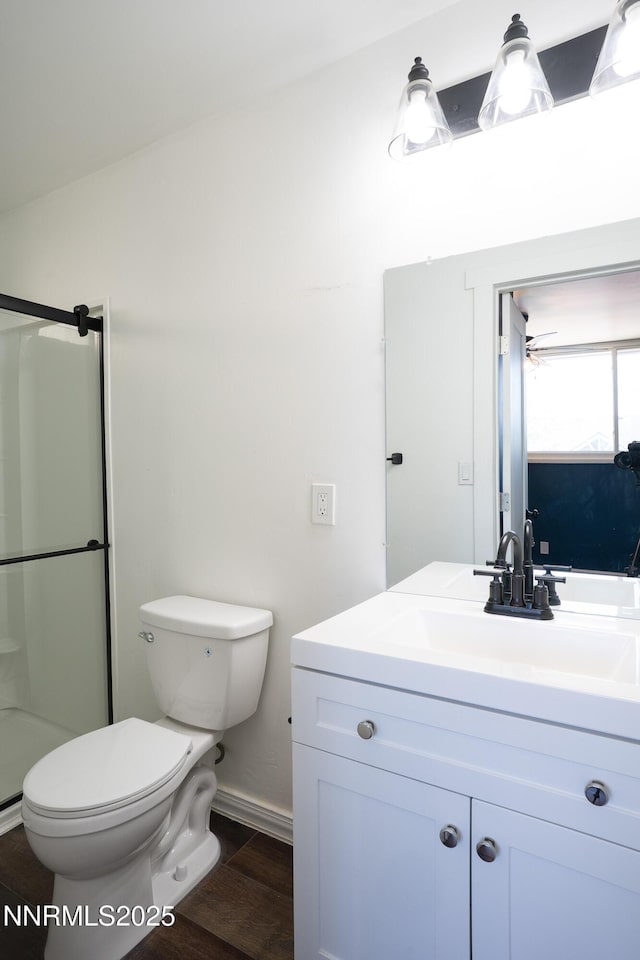 435 Ardmore Dr, Reno, NV 89509 - bathroom featuring toilet, vanity, a shower with door, wood finished floors, and baseboards