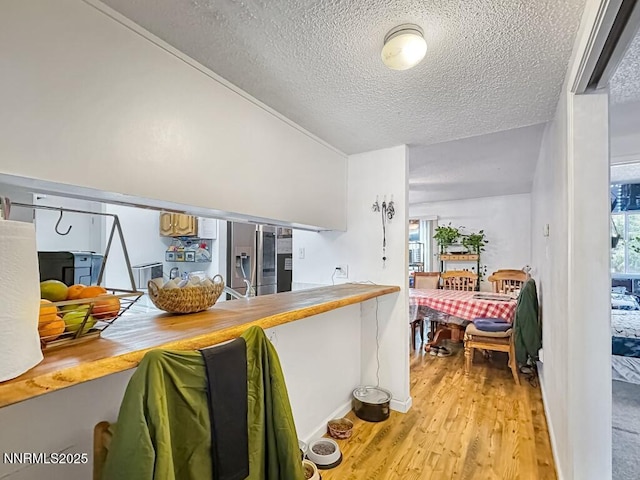 1714 Meadowvale Way, Sparks, NV 89431 - kitchen featuring stainless steel fridge with ice dispenser, a textured ceiling, light wood-type flooring, and baseboards