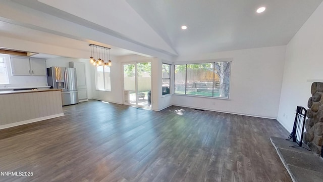 6042 Walnut Creek Rd, Reno, NV 89523 - unfurnished living room featuring plenty of natural light, a fireplace, dark wood-style flooring, vaulted ceiling, and a chandelier