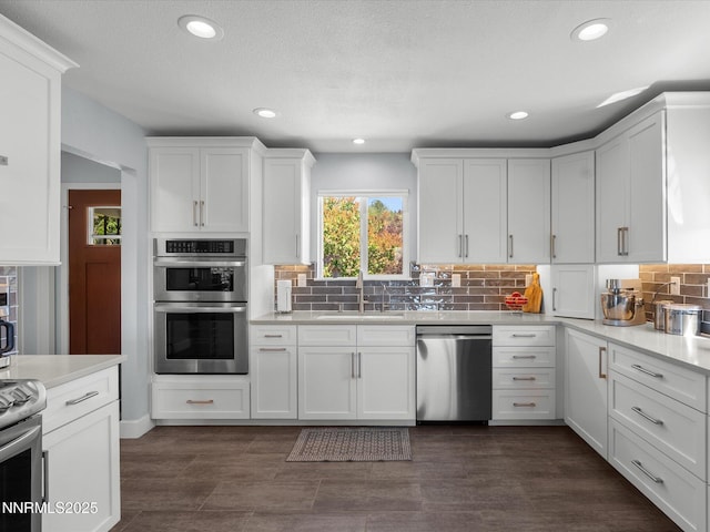 60 Redstone Dr, Reno, NV 89512 - kitchen featuring stainless steel appliances, a sink, white cabinets, backsplash, and recessed lighting