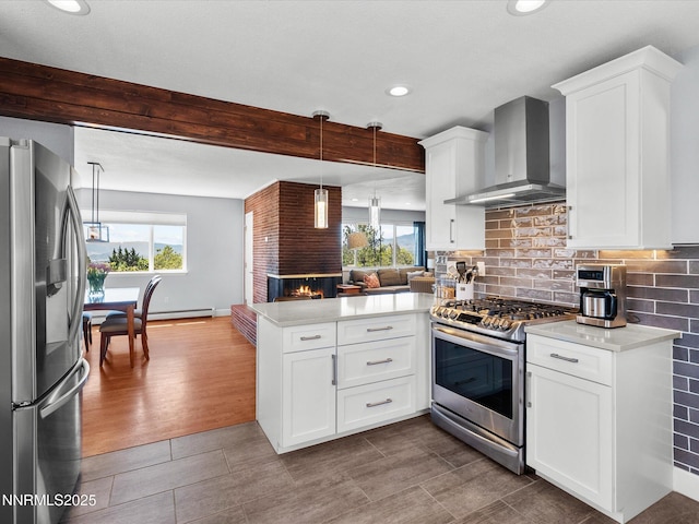 60 Redstone Dr, Reno, NV 89512 - kitchen featuring appliances with stainless steel finishes, wall chimney exhaust hood, a peninsula, open floor plan, and light countertops