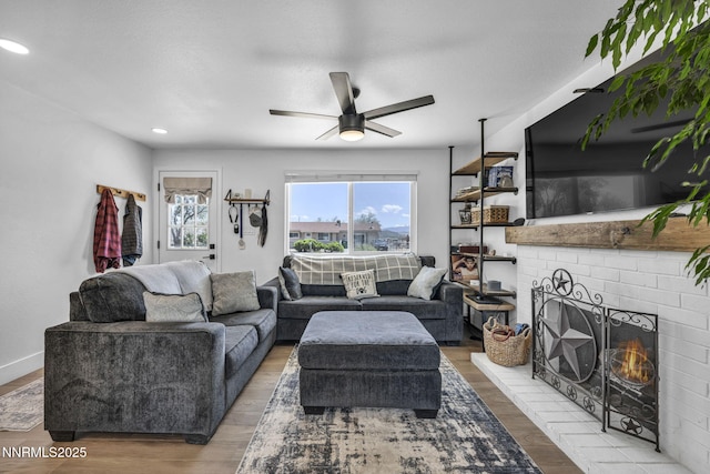 11471 Sitka St, Reno, NV 89506 - living area with a ceiling fan, wood finished floors, a brick fireplace, recessed lighting, and baseboards