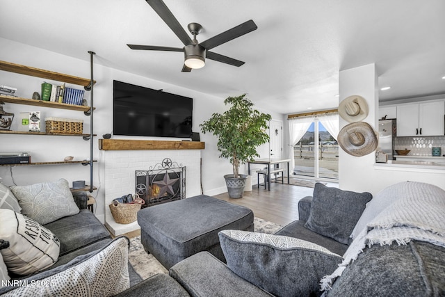 11471 Sitka St, Reno, NV 89506 - living area featuring a ceiling fan, wood finished floors, a brick fireplace, and baseboards