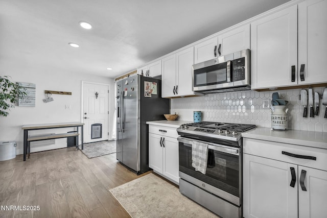 11471 Sitka St, Reno, NV 89506 - kitchen featuring appliances with stainless steel finishes, light countertops, light wood-style floors, white cabinetry, and backsplash